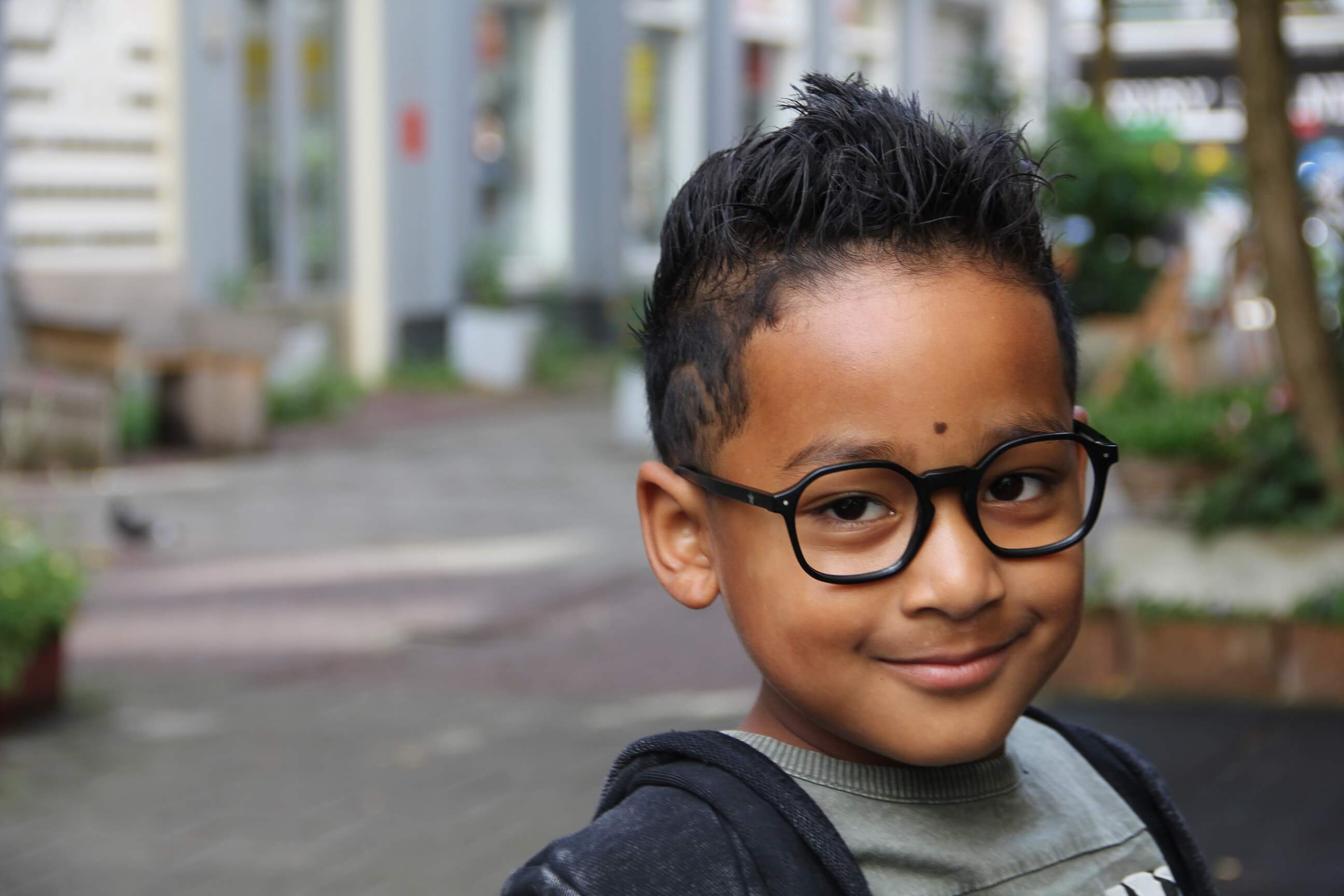 Jongen met een kinderbril na een oogmeting bij Kidzz Eyezz