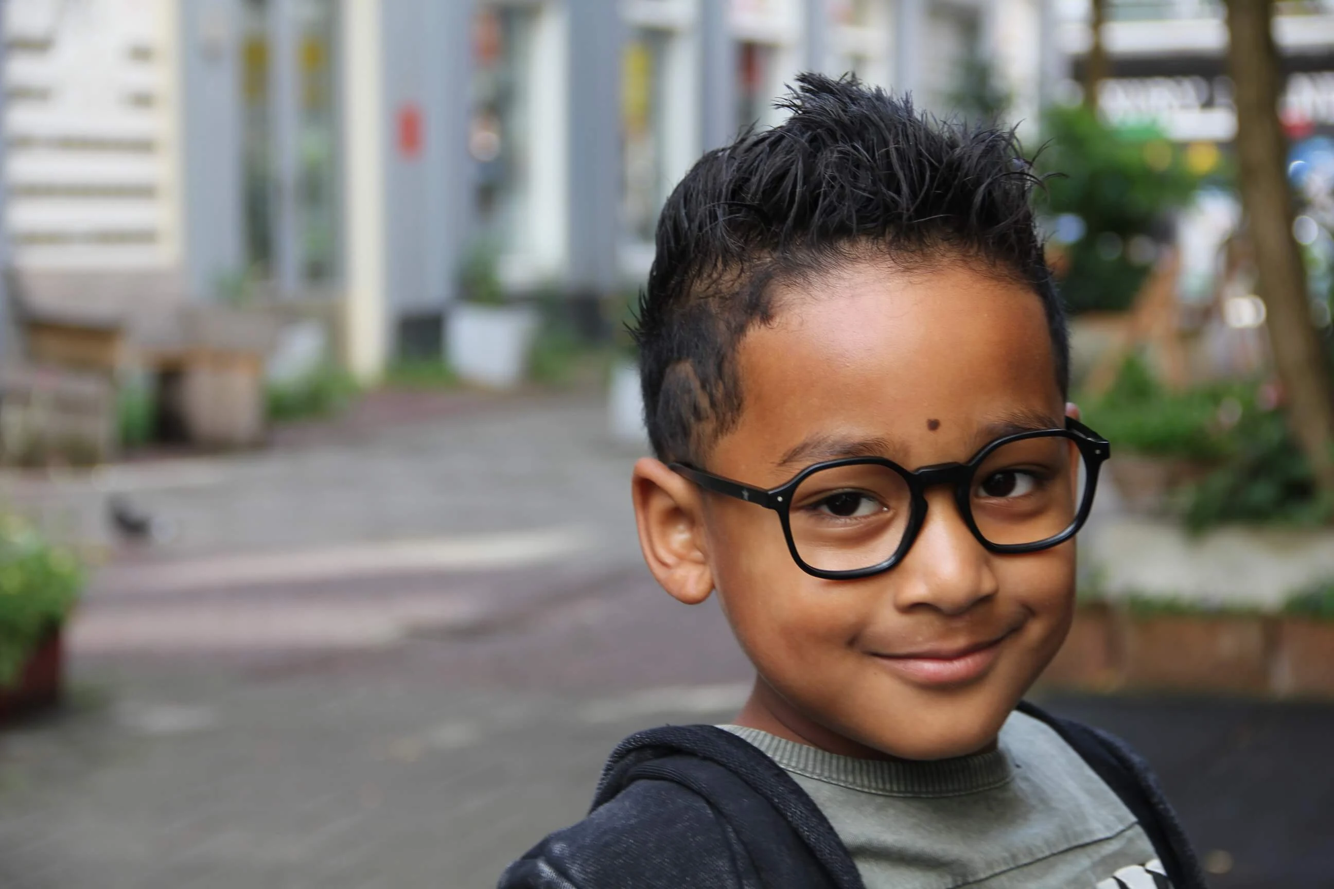 Jongen met een kinderbril na een oogmeting bij Kidzz Eyezz
